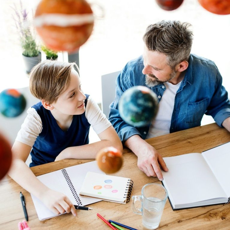 UK Professional Tutors & Teachers | London | Overseas A man and a boy sit at a table, discussing a model solar system. Professional Tutors & Teachers. UK.